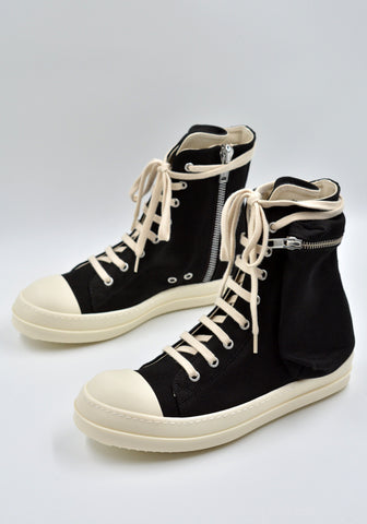 Cargo sneakers featuring a black cotton denim upper, above ankle height, eight eyelets, shoe lace, zipped cargo side pockets, milk white leather toe caps and shark tooth rubber soles