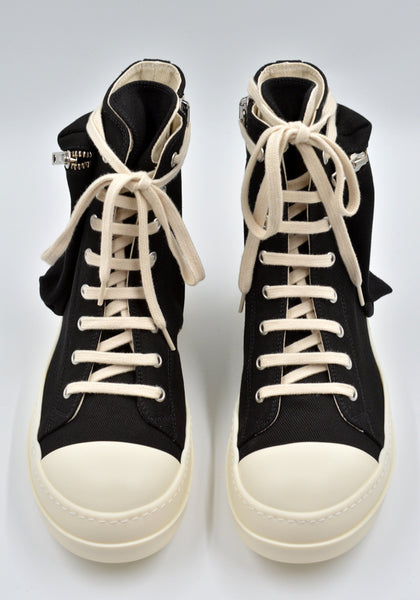 Cargo sneakers featuring a black cotton denim upper, above ankle height, eight eyelets, shoe lace, zipped cargo side pockets, milk white leather toe caps and shark tooth rubber soles