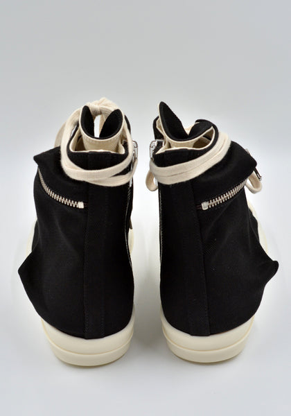 Cargo sneakers featuring a black cotton denim upper, above ankle height, eight eyelets, shoe lace, zipped cargo side pockets, milk white leather toe caps and shark tooth rubber soles